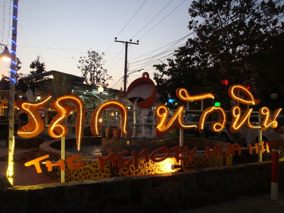 Complex sign with fountain behind at dusk