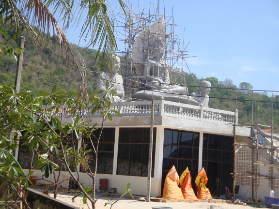 3 Buddha images being built on top of a new building