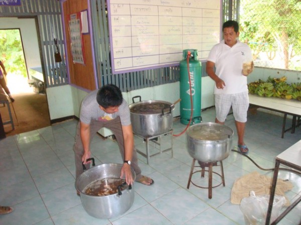 3 huge saucepans on large improvised gas cookers