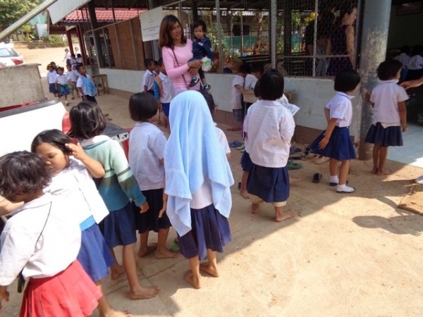 queuing up to wash their hands in a bucket of water