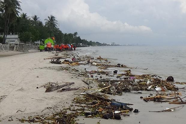 Workers and volunteers collect trash and debris blown ashore by seasonal winds in Hua Hin district of Prachuap Khiri Khan on Monday. (Photo by Chaiwat Satyaem