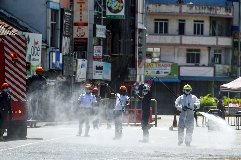 Firefighters spray disinfectant to sanitise a road as a preventive measure against the coronavirus in Colombo, Sri Lanka on May 10, 2020.