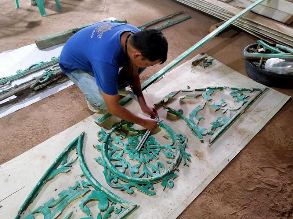 A fine arts official is assembling debris that used to decorate the gable of ancient Bombay Burmah house that was torn down in a restoration project. (Picture courtesy of Fine Arts Department)