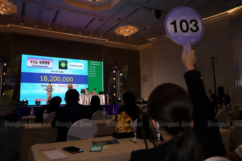 A woman bids on the Ror Wor Yor 9999 licence plate in an auction held by the Department of Land Transport on Thursday. It eventually sold for 18.5 million baht. (Photo: Chanat Katanyu)